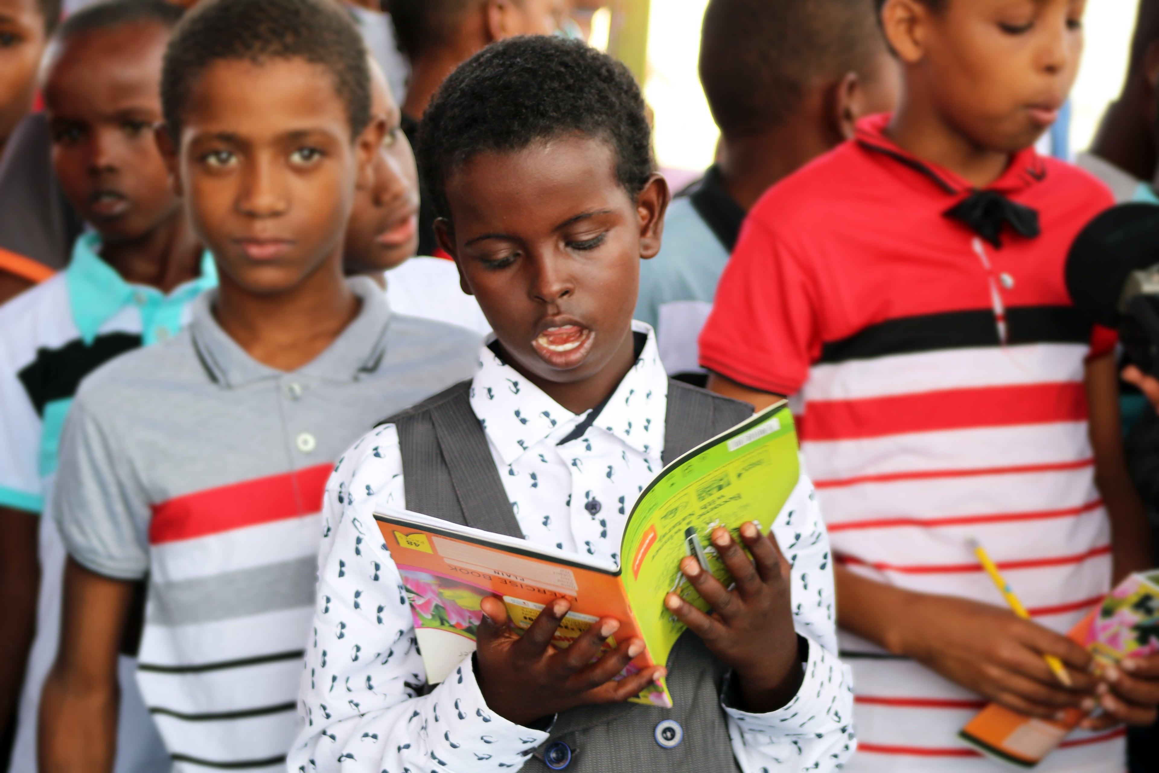 young boy reading from a book