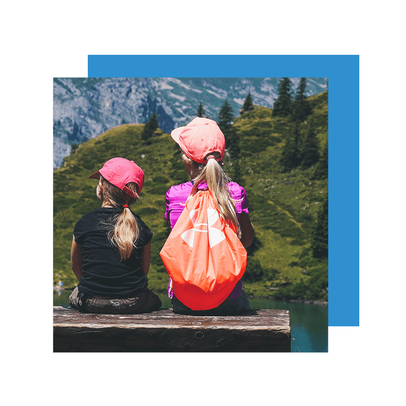 two kids with orange caps staring at the mountain
