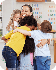 Care, teacher with school children hug and in a classroom with a lens flare. Support or love, happiness or teaching and happy or cheerful woman with kindergarten kids hugging together in a class.
