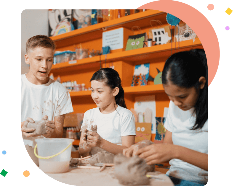 Happy diverse highschool student modeling clay at pottery workshop. Cute children with mixed raced working and making cup of clay by using carving equipment at art lesson. Creative class. Edification.