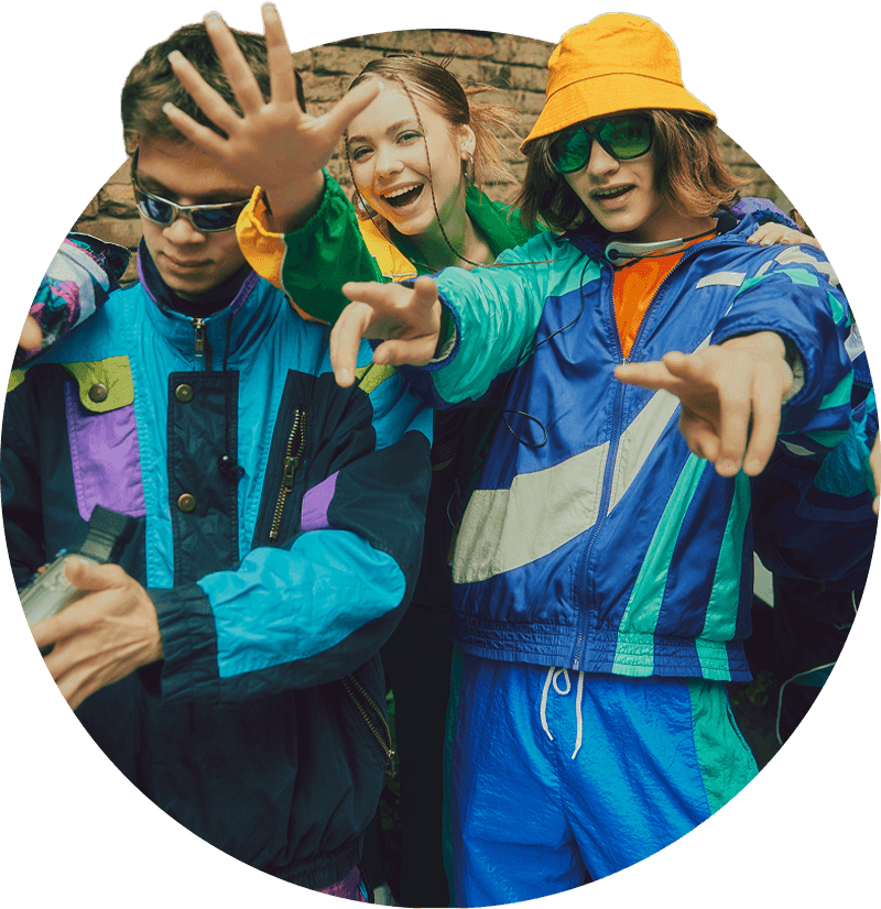 Vintage aesthetic fashion. Young people, friends wearing colorful athletic sportswear, trendy accessories posing in striking pose against urban backdrop. Concept of 90s, fashion, youth culture